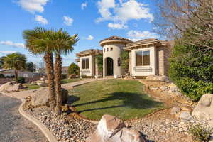 Mediterranean / spanish home featuring a front yard, stucco siding, a tiled roof, and stone siding