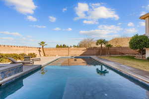 View of swimming pool featuring a fenced backyard and patio surround
