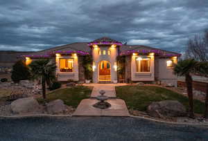 Mediterranean / spanish-style home featuring stucco siding, a front yard, and a tile roof