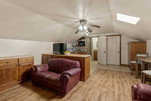 ADU Greatroom w/ light wood finished floors, a ceiling fan, and a skylight