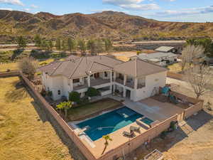 Back of property with a patio area, a balcony, a fenced backyard, a mountain view, and stucco siding