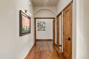 Hallway with dark wood finished floors and baseboards