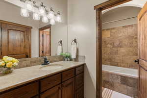 Bathroom featuring vanity and tiled shower / bath