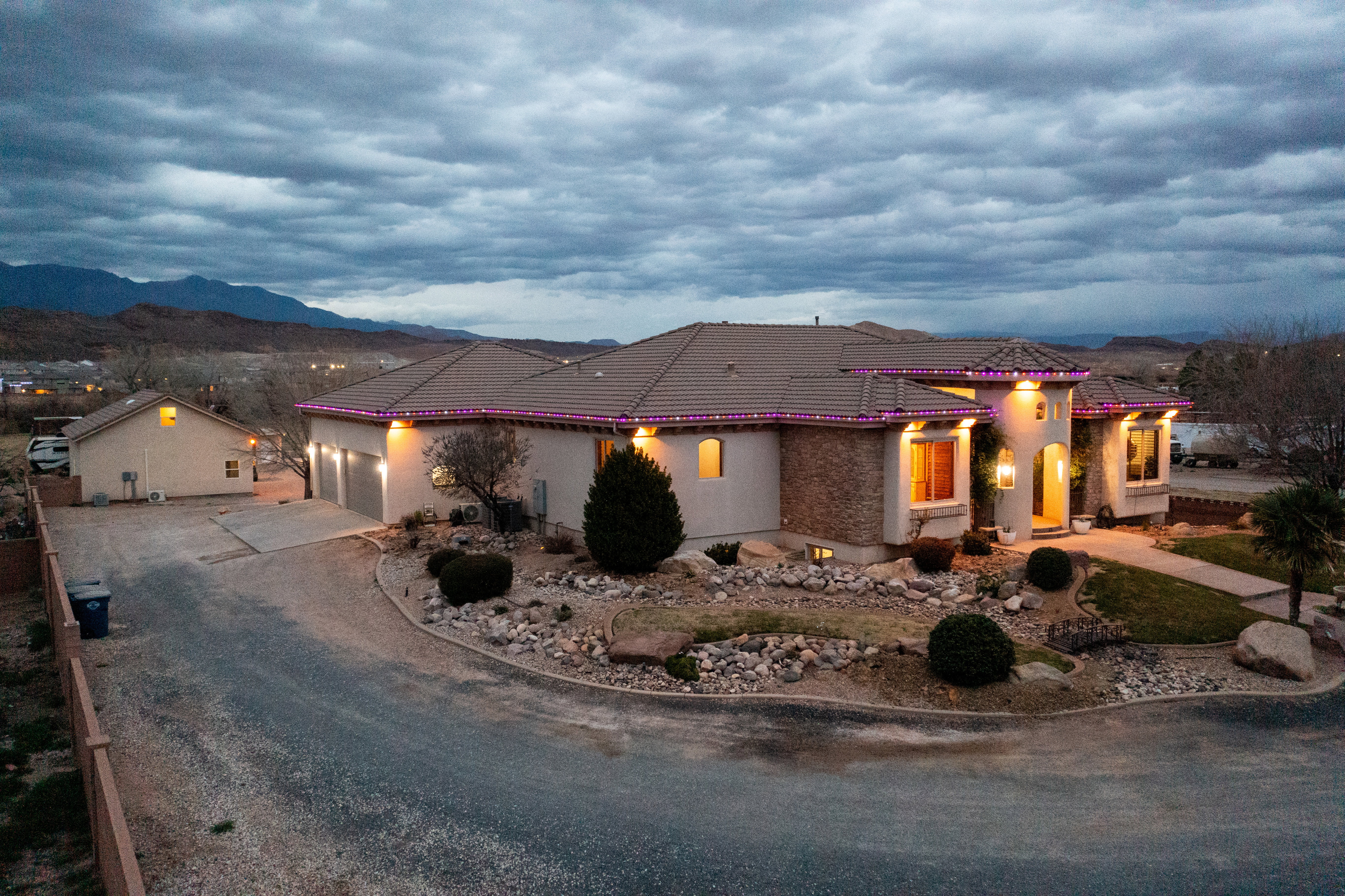 Mediterranean / spanish-style house with driveway, a tiled roof, stucco siding, an attached garage, and a mountain view