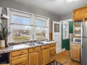 Kitchen with freestanding refrigerator, light wood finished floors, a ceiling fan, and wood finish cabinets