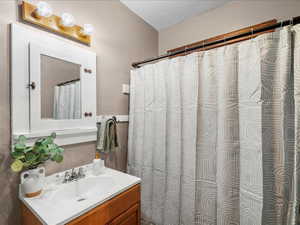 Full bathroom with vanity and curtained shower