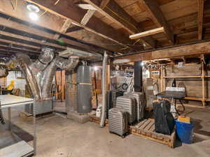 Unfinished basement featuring water heater and heating unit