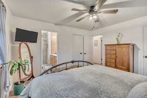 Bedroom with a closet, ceiling fan, and connected bathroom
