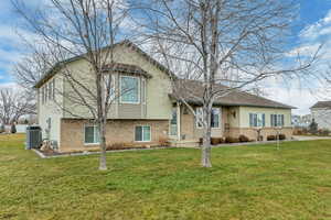 Tri-level home featuring brick siding and a front lawn