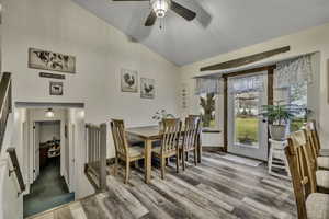 Dining space featuring a ceiling fan, vaulted ceiling, and wood finished floors