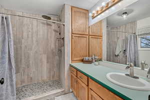Bathroom with tiled shower and vanity