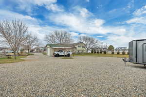 View of yard with a residential view, an outbuilding, and a carport