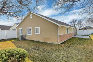 View of property exterior featuring a gate, a fenced backyard, stucco siding, and brick siding