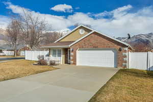 Single story home featuring brick siding, driveway, a garage, covered porch, and a mountain view