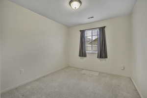 Carpeted empty room with baseboards