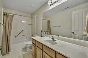 Bathroom featuring vanity and shower / bath combination with curtain