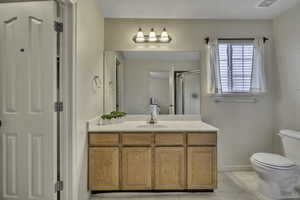 Bathroom with vanity, a stall shower, and light tile patterned floors