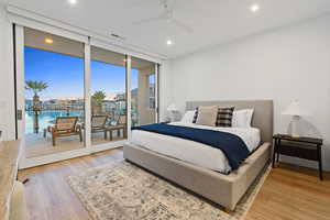 Bedroom featuring expansive windows, light wood-style flooring, a ceiling fan, access to exterior, and recessed lighting
