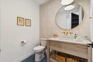 Bathroom featuring tile walls, vanity, and tile patterned flooring