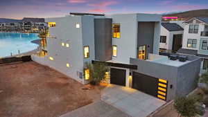 Modern home with stucco siding, concrete driveway, an attached garage, and a patio