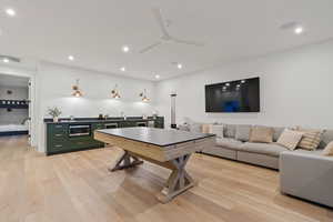 Recreation room featuring light wood-style floors, a ceiling fan, recessed lighting, and wine cooler