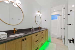 Bathroom featuring shower / tub combo and double vanity