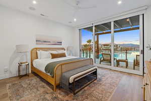 Bedroom featuring expansive windows, light wood finished floors, access to outside, recessed lighting, and ceiling fan