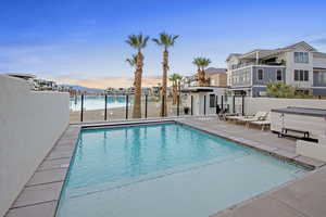 View of swimming pool with patio surround, a jacuzzi, and a residential view