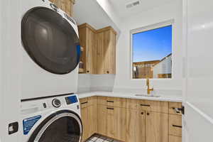 Laundry room with cabinet space and stacked washer and dryer