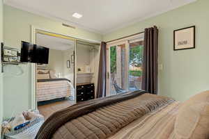 Tiled bedroom featuring ornamental molding, access to exterior, and a closet