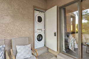 View of exterior entry with stacked washing machine and dryer