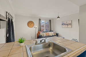 Kitchen featuring tile countertops and crown molding