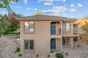 View of front of property featuring a balcony and stucco siding