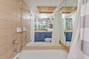 Full bathroom with shower / tub combo with curtain and vanity