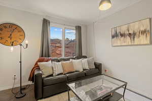 Living area with ornamental molding and baseboards