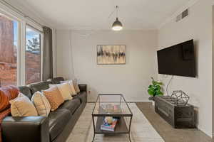 Living area featuring crown molding and baseboards