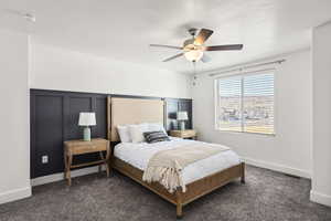 Bedroom featuring a ceiling fan, carpet, and a textured ceiling