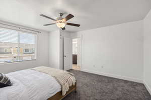Bedroom with carpet, ceiling fan, a textured ceiling, and ensuite bath