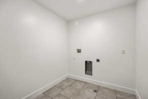 Laundry area featuring light tile patterned floors, hookup for a washing machine, and hookup for an electric dryer