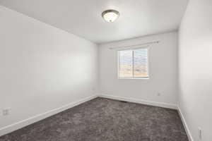 Unfurnished room featuring dark carpet and a textured ceiling