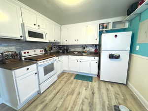 Kitchen featuring area with dark countertops and upgraded backsplash.