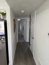 Hall featuring dark wood finished floors and a textured ceiling