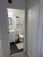Half bathroom featuring vanity and dark tile patterned flooring