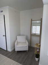 Sitting room featuring dark wood-type flooring, a textured ceiling, and crown molding