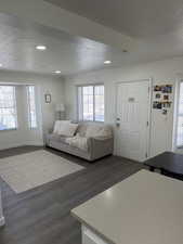 Living area featuring a textured ceiling, dark wood finished floors, recessed lighting, and ornamental molding