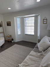 Bedroom featuring dark wood-style floors, recessed lighting, a textured ceiling, and ornamental molding
