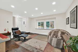 Sitting room with dark wood-type flooring and recessed lighting