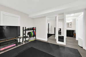 Workout room with light wood-style flooring and baseboards