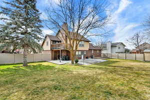 Rear view of property with brick siding, a patio area, and a fenced backyard