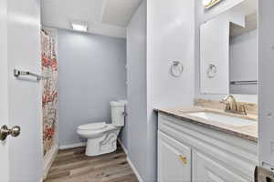 Full bath with a shower with shower curtain, vanity, and light wood-style floors